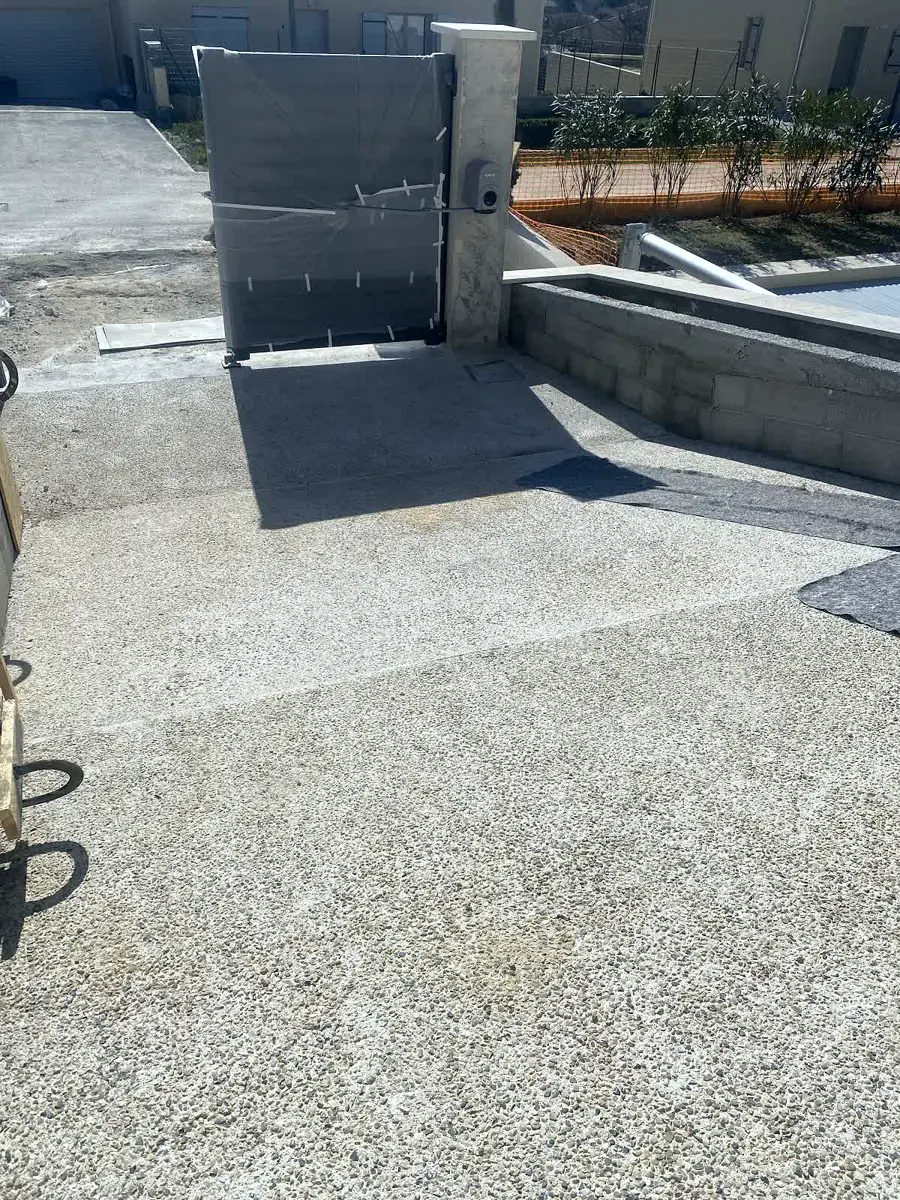 Cour en béton désactivé avec muret maçonné