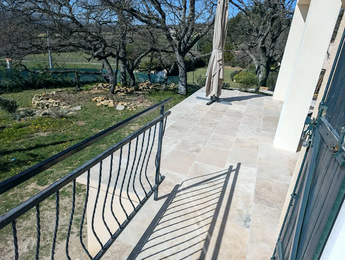 Terrasse en travertin avec garde-corps en fer forgé